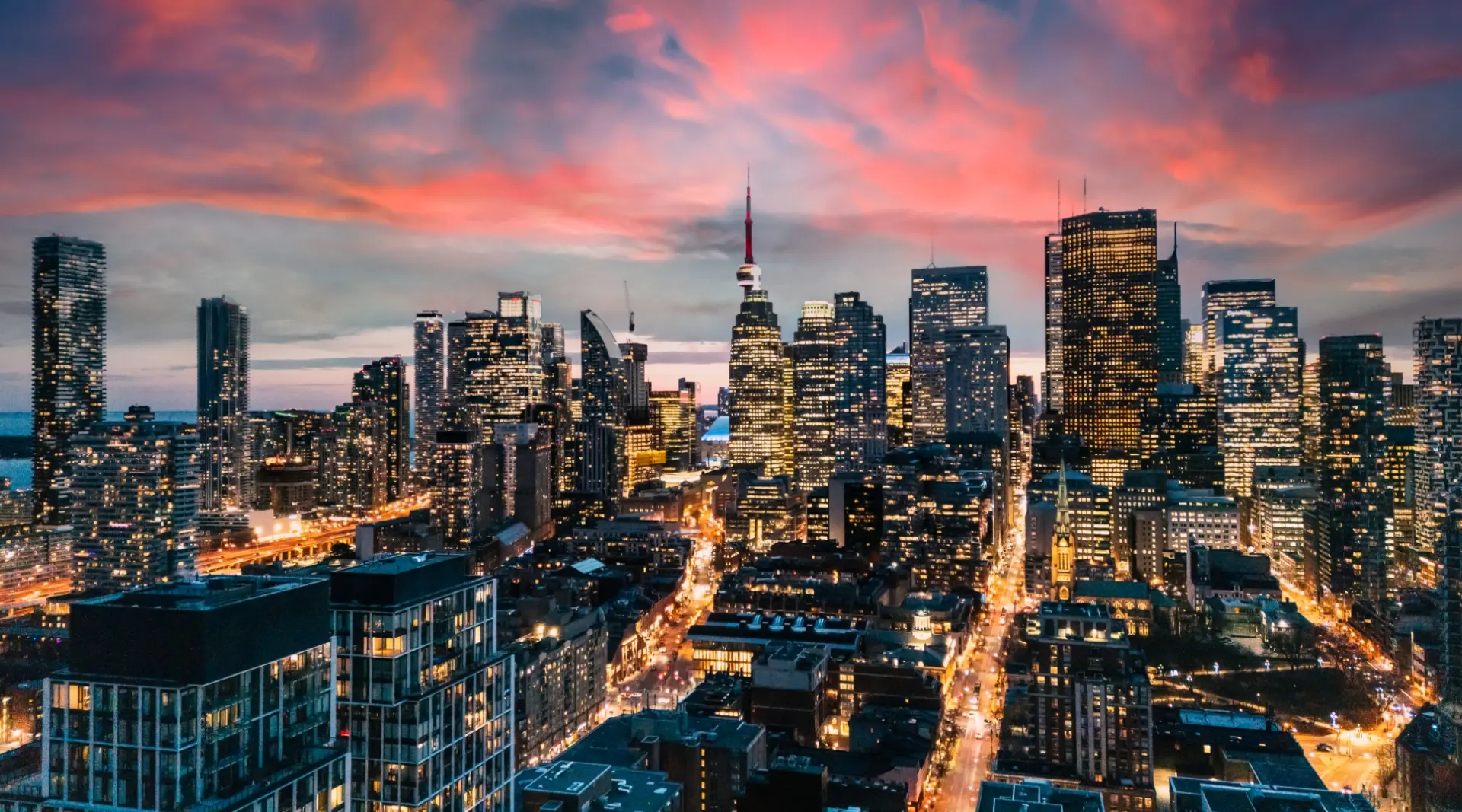 The downtown Toronto skyline lit up at sunset, seen from above